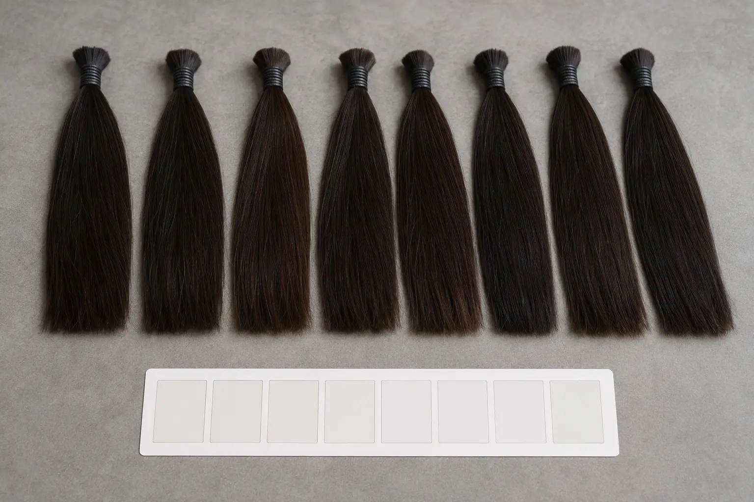 Dark human-hair samples arranged to compare color and undertone consistency